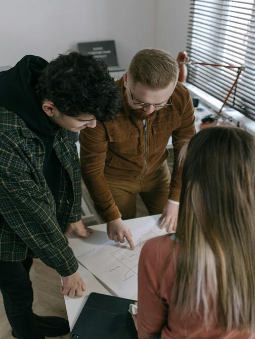 A person's hands operating a computer, displaying a detailed 3D model of a complex piping system in a CAD software.