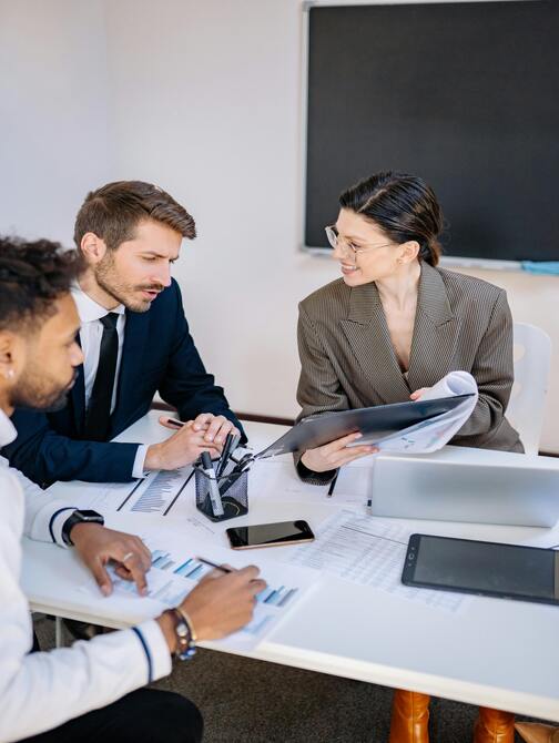 A multidisciplinary team in a conference room in Mumbai, India, engaged in a brainstorming session, outlining concepts and strategies on a whiteboard.